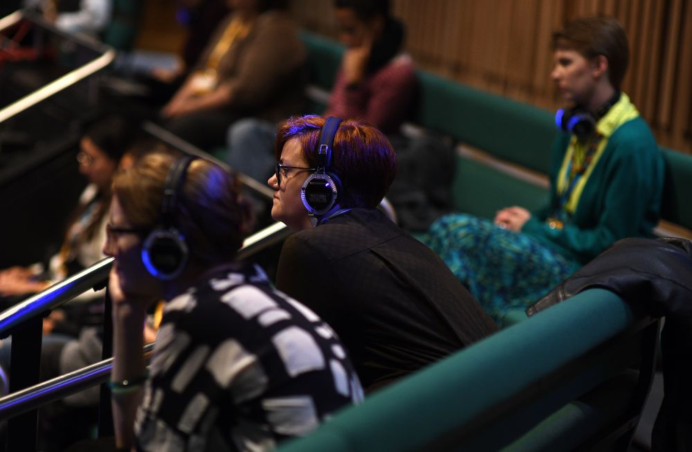 Photo of audience wearing wireless headphones with blue lights
