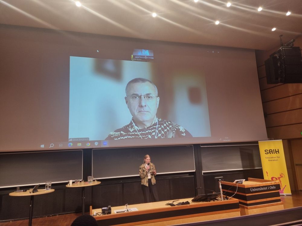 President of SAIH, Selma Bratberg, in front of a screen where Omar Barghouti has joined on Zoom 