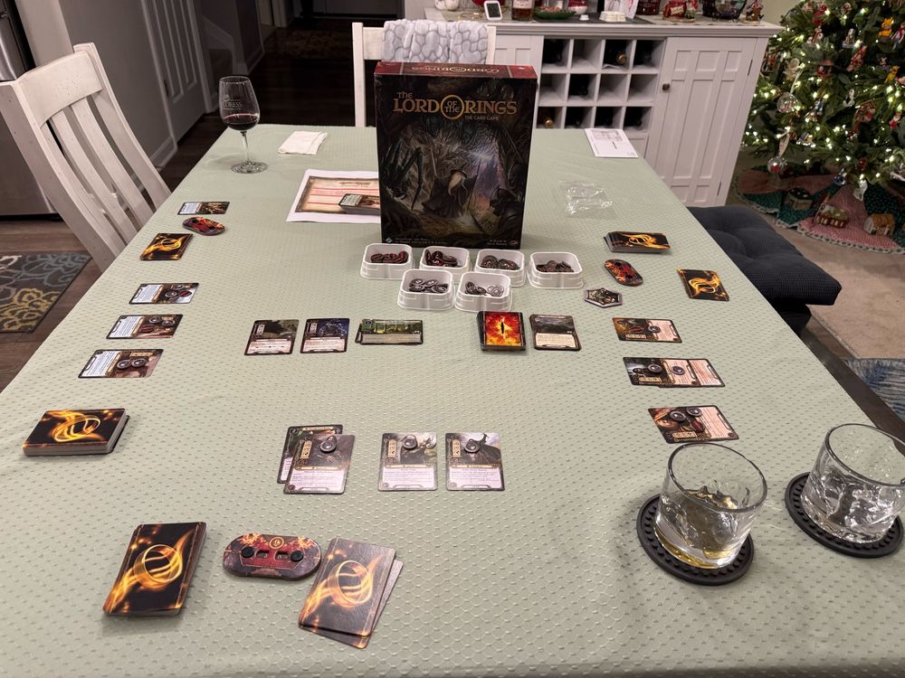 My table set up with the Lord of the Rings Card Game, a couple glasses of bourbon for me and my son, and a glass of wine for my wife. 
