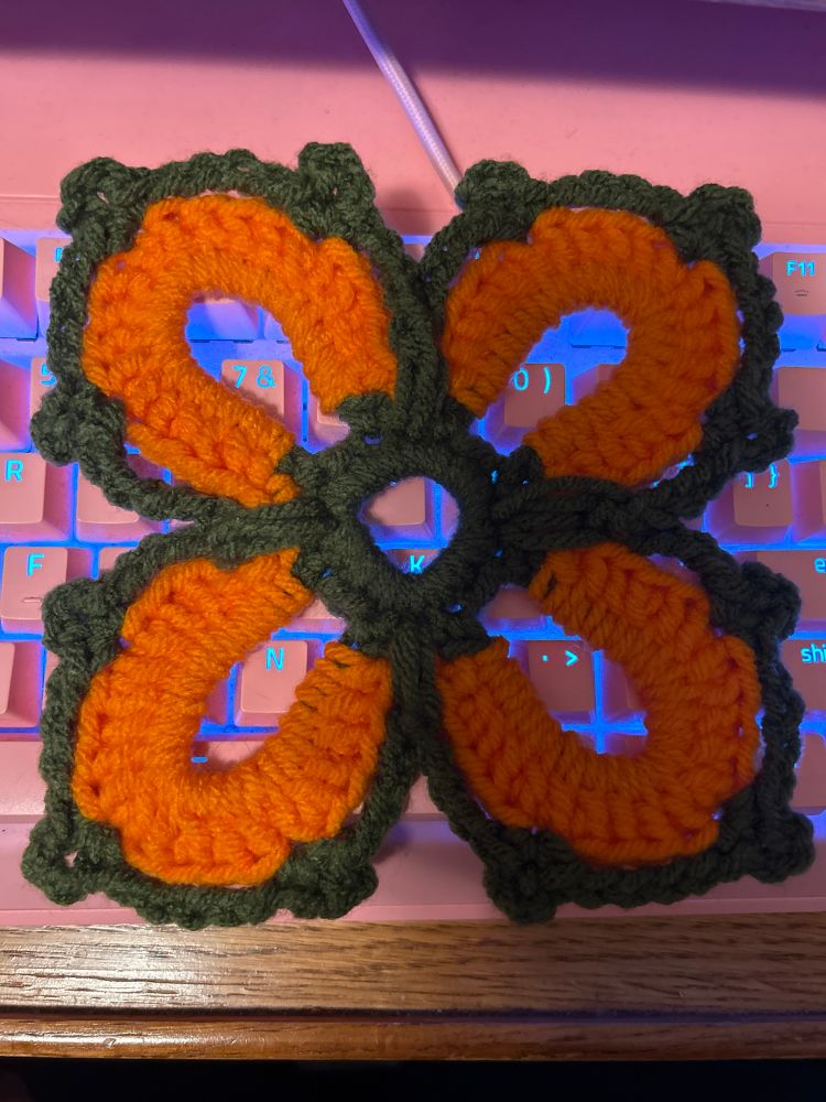 Crochet square motif over a glowing mechanical keyboard 
