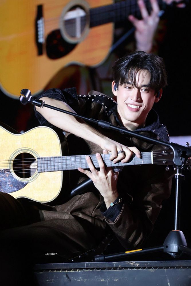 ギターとマイクを持って姿勢を整えようとしているらしい笑顔のGawinさん。