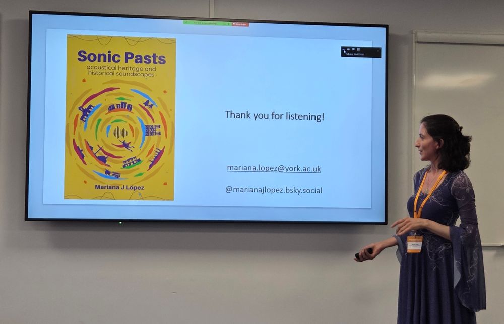 Mariana Lopez posing with an image of her book 'Sonic Pasts: Accoustical Heritage and Historical Landscapes' 