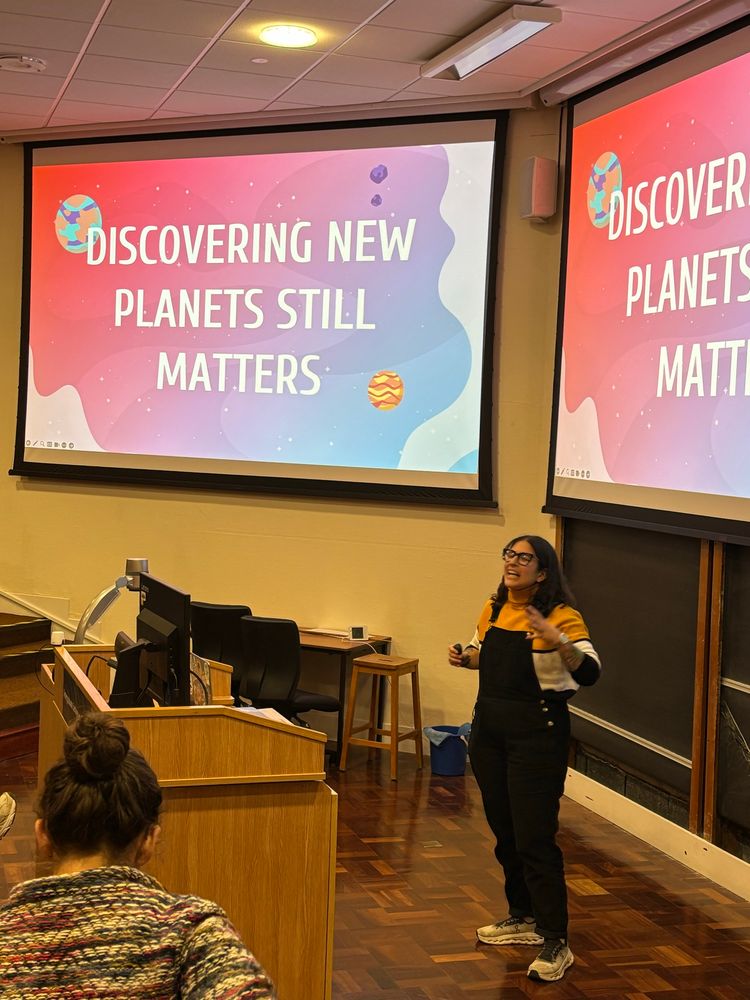 An enthusiastic speaker stands in a lecture theatre that says ‘discovering new planets still matters’
