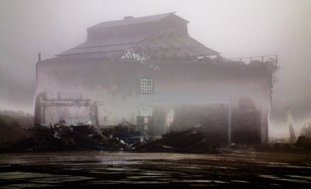 A view, through heavy mist, of a building at the former Henley's/AEI site at Northfleet, Kent. A building, surrounded by the remains of other buildings and shrouded in mist, with the sun attempting to break through the mist from behind. Taken 20 November 2011 with a Fujifilm FinePix HS10.