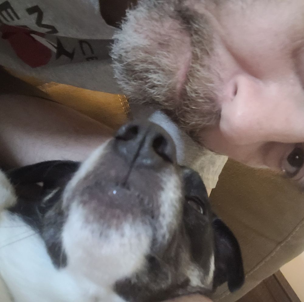 Half my face posing with my lazy dog who is showing off his wonderful snoot