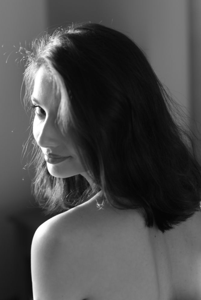 A headshot in black and white of a lovely nude brunette