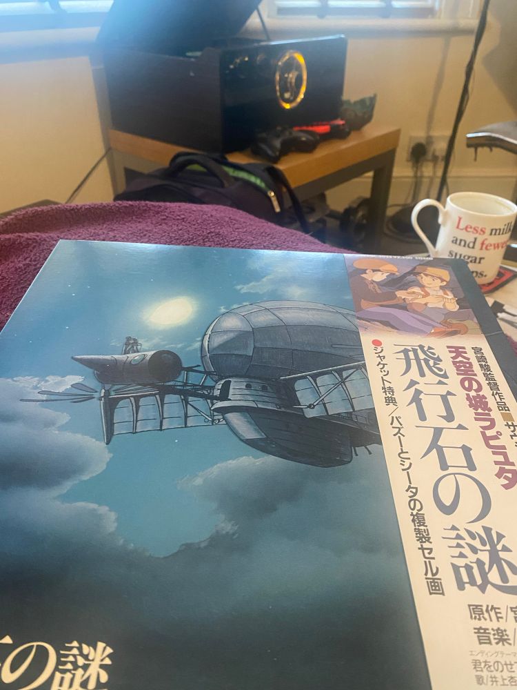 Record sleeve for the soundtrack to ‘Laputa: Castle in the Sky’ on a cushion before a record player.