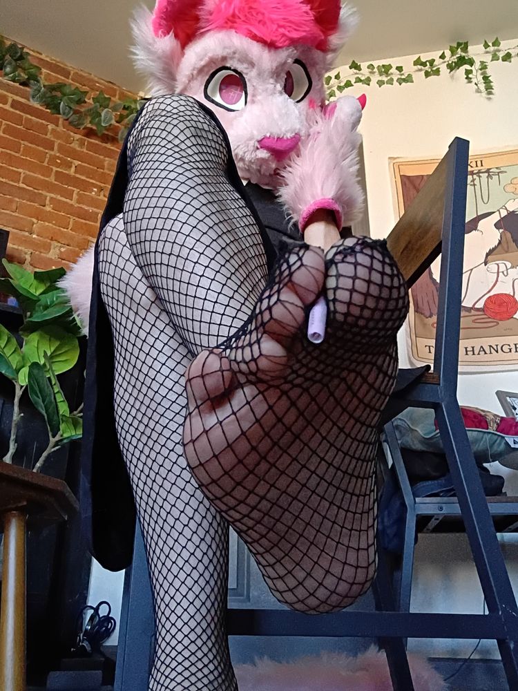 Felicity holding a small pink joint between his toes while wearing fishnets!
