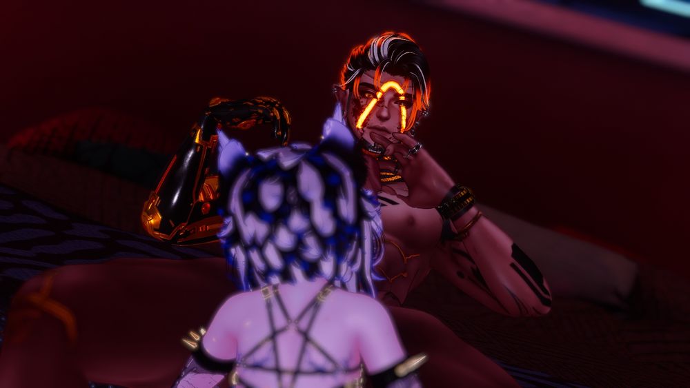 Two people in picture. 
An Eboy with orange hair, decorated in gold, and cybernetics. With a femboy with blue hair, cat ears, and stars on his body. The femboy is sucking the orange eboy off in various poses. 
