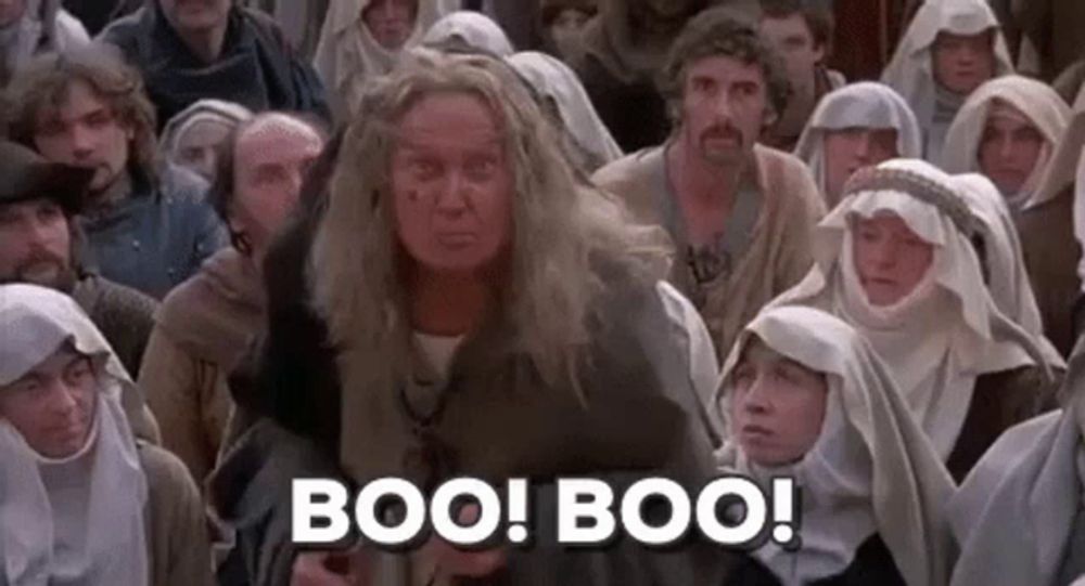 a woman is standing in front of a crowd of people and says boo ! boo !