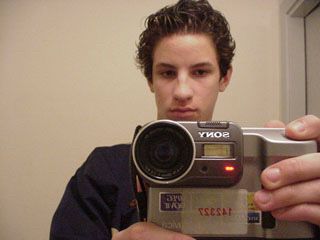 Photo of me holding a digital camera in a mirror.