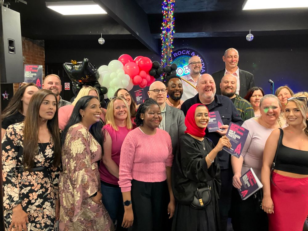 People smiling holding the book