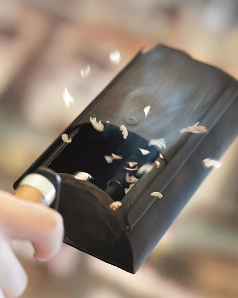 Frische Kaffeebohnenreste oder Silberhäutchen fliegen aus einem Röster in die Luft.