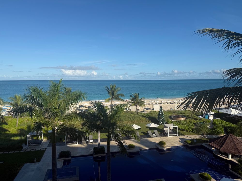 A pool, with the beach and ocean beyond
