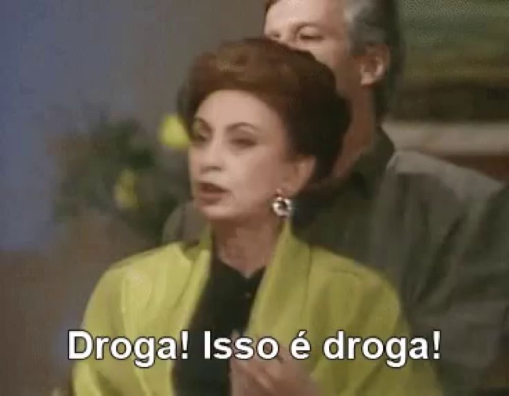 a woman in a yellow jacket is standing next to a man and saying droga ! isso é droga !