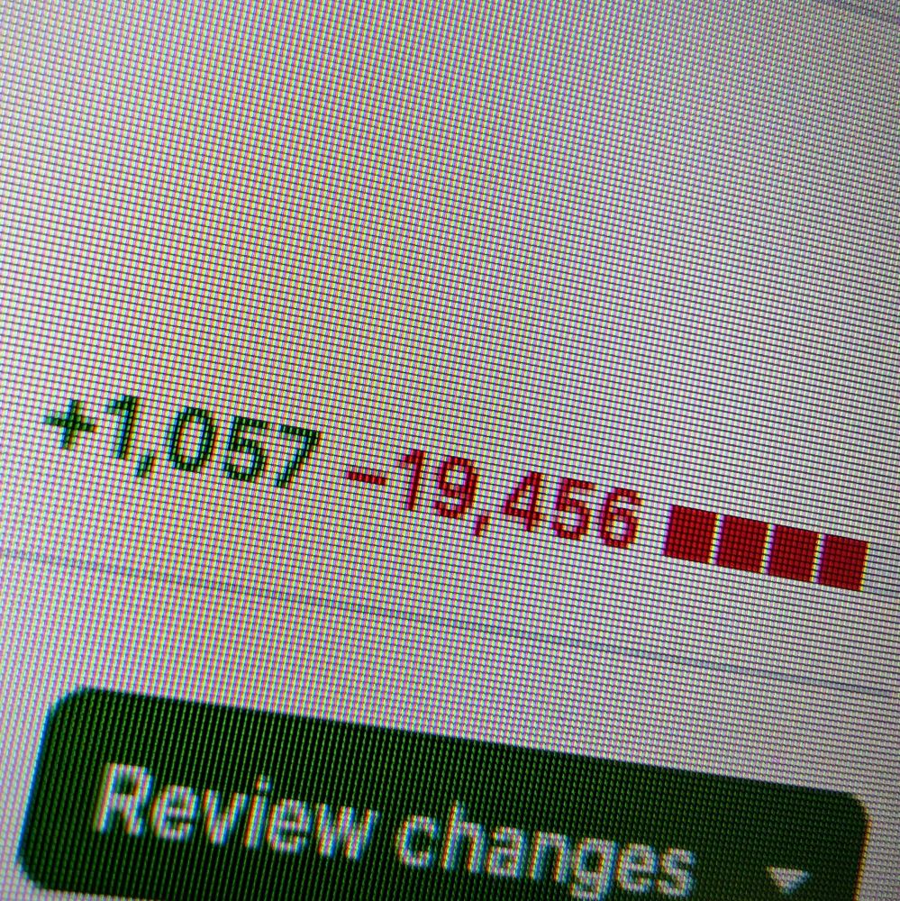 Photo of a screen showing a github pull request page, zoomed in close to the part that shows 1,057 lines added and 19,456 lines removed