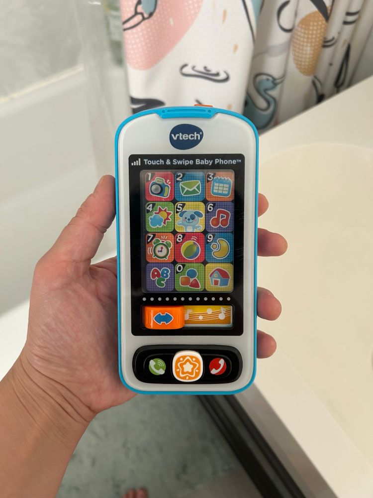 My hand holding V tech baby phone toy