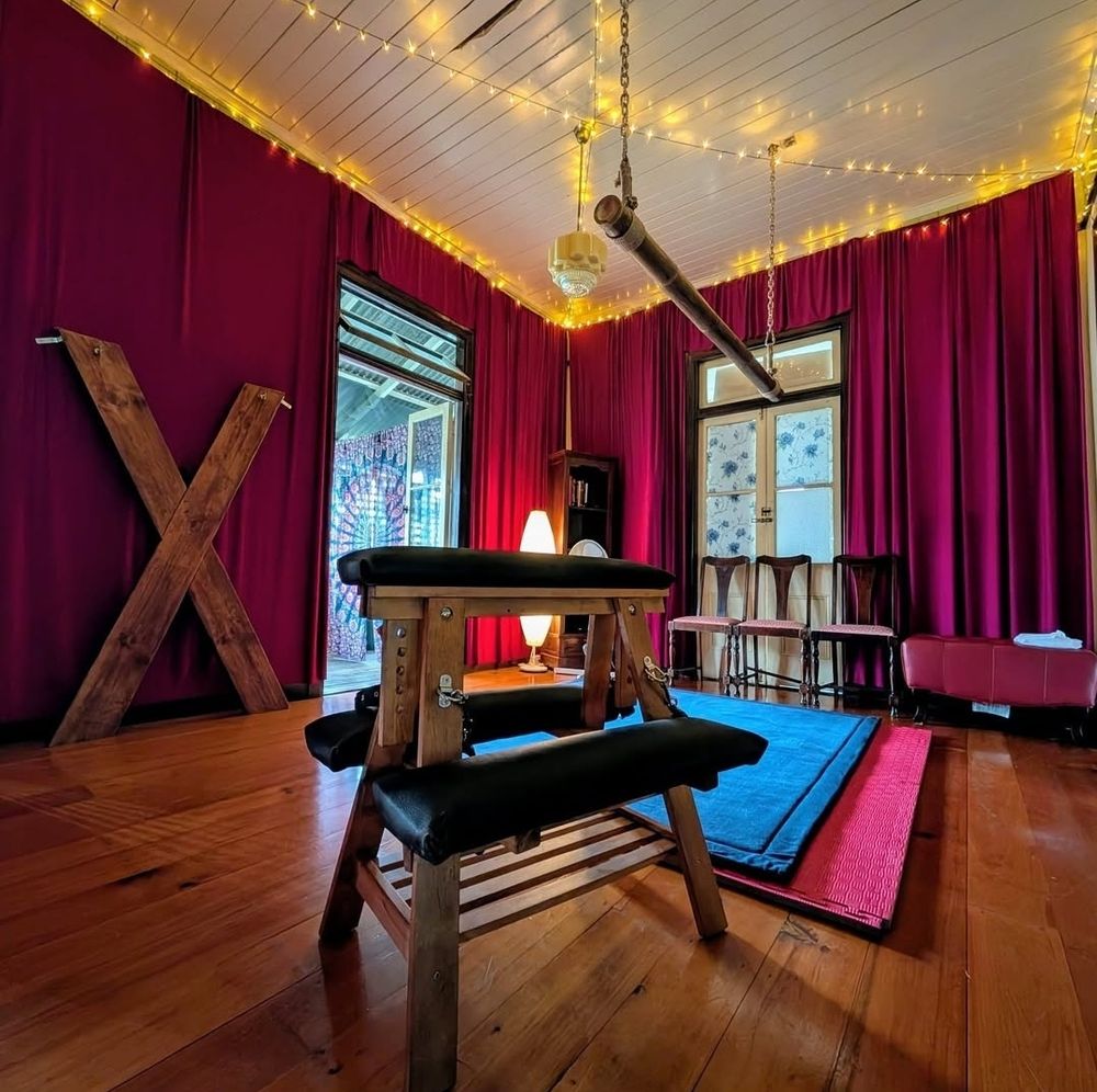 Picture of a BDSM dungeon with a spanking bench in the foreground of the photo