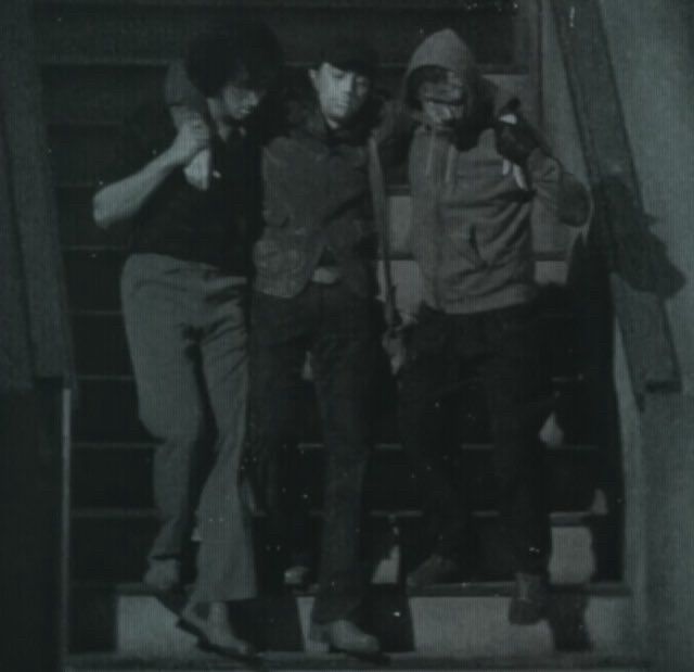 armand and louis walking an unconscious young daniel down the stairs of their san francisco apartment