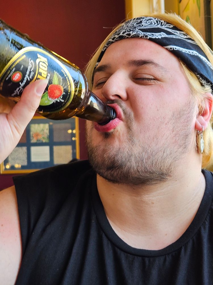 Me drinking out a bottle of Strawbeery & Lime Kopparberg in the pub