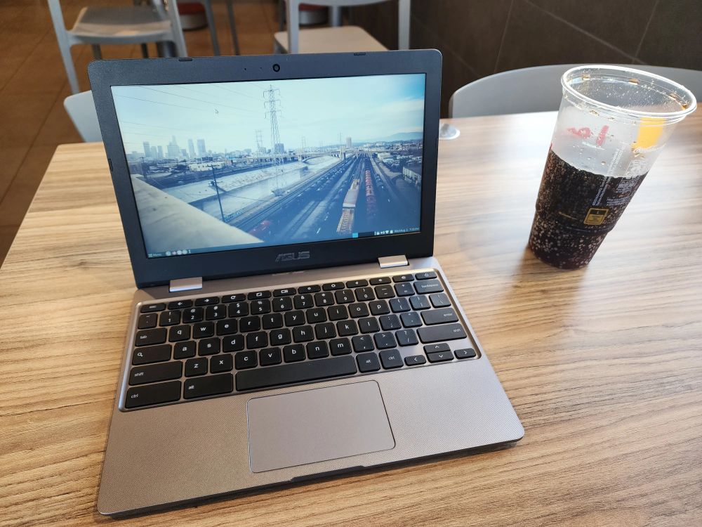 he Asus Chromebook CX22NA running Debian 12. Shot of the laptop on a table at McDonald's.