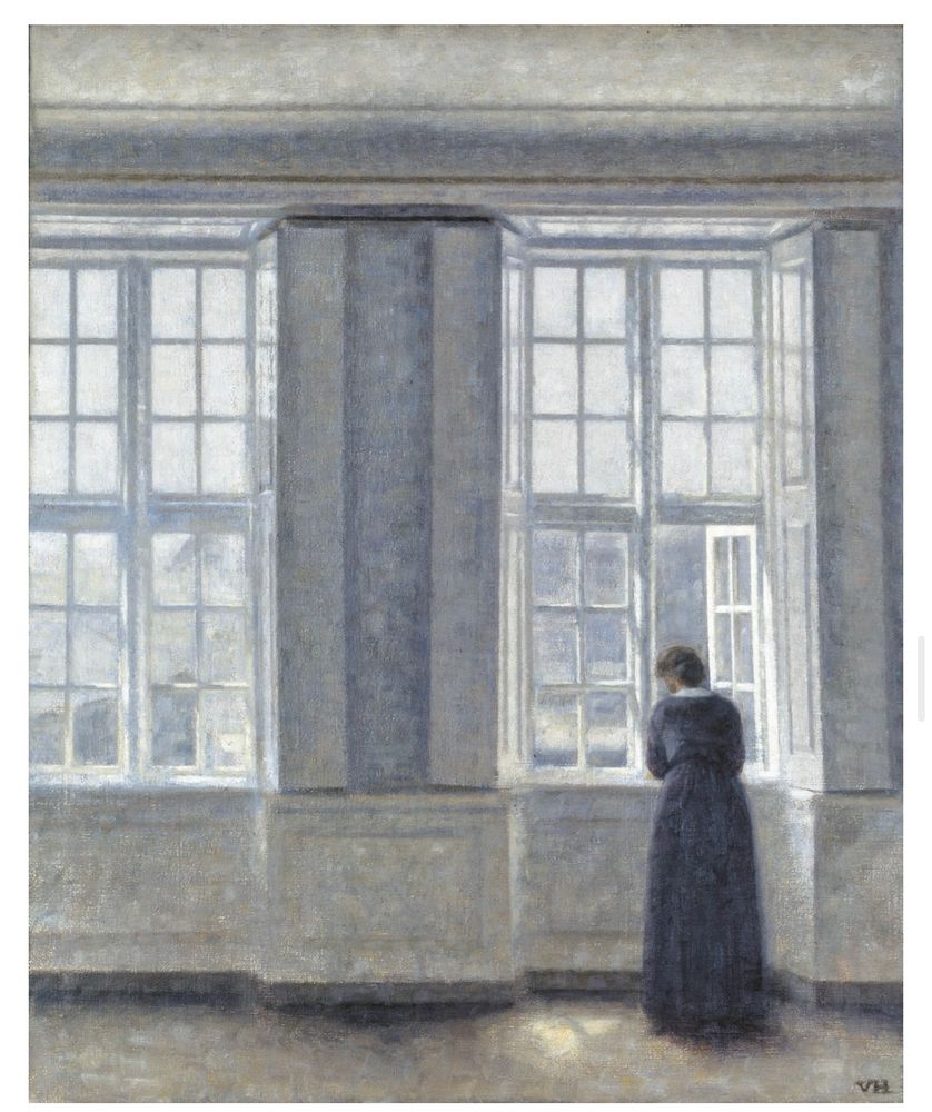 This image is a painting with a calm, quiet, and almost meditative atmosphere.

It shows a tall, bright room dominated by large, multi-paned windows. Soft daylight floods in, casting pale blue and white tones across the space. The walls, window frames, and light are all painted in muted, cool colors, giving the scene a serene but slightly melancholic mood.

A solitary woman stands in the lower right part of the painting, facing the windows. She wears a long, dark dress that contrasts with the light around her. Her posture is slightly hunched, her head bowed, and her hands seem to rest on the windowsill as she looks outside.

The room is empty except for her—no furniture, no clutter—just the interplay of light and shadow. The overall feeling is one of stillness, introspection, and waiting.