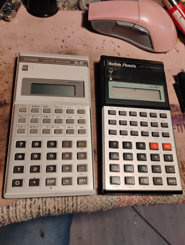A Casio FX-81 calculator next to a Radio Shack calculator that is the exact same model but with different colours