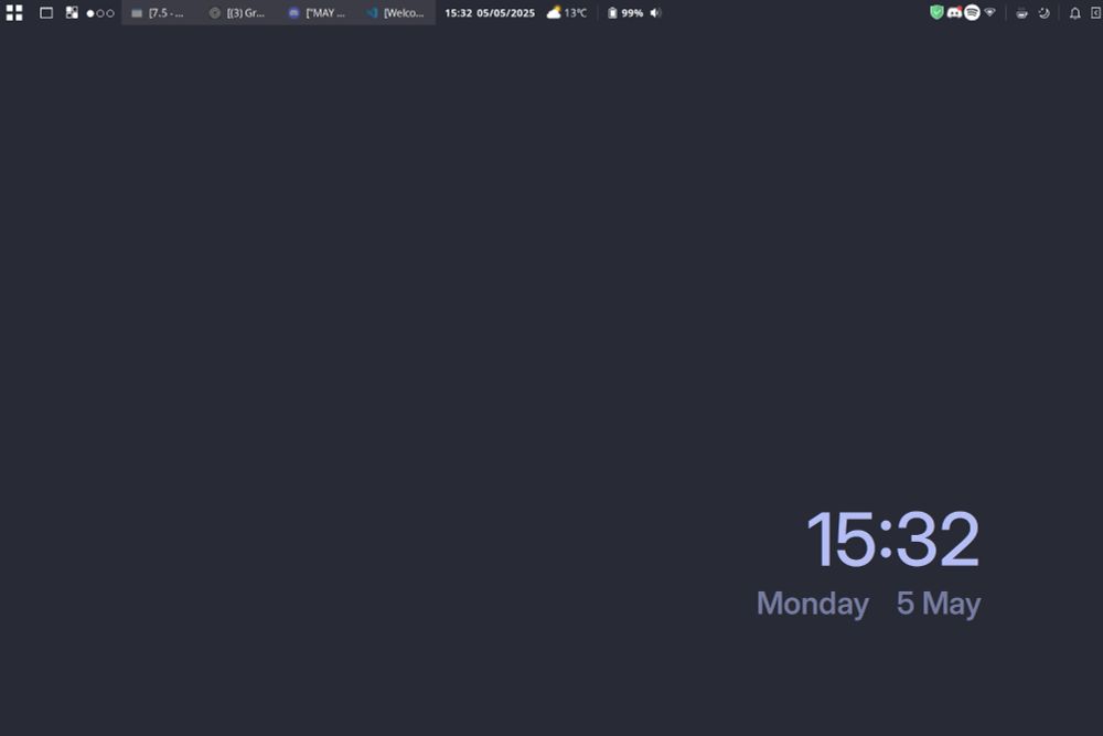 A screenshot of a linux background. There is a custom top panel with running programs in the top left, the center contains the date, weather and battery status and the top right includes the system tray icons. There is no bottom panel. The background is a dark blue and the only thing showing is the date which is 15:32 Monday 5 May which show in a lighter shade of blue.