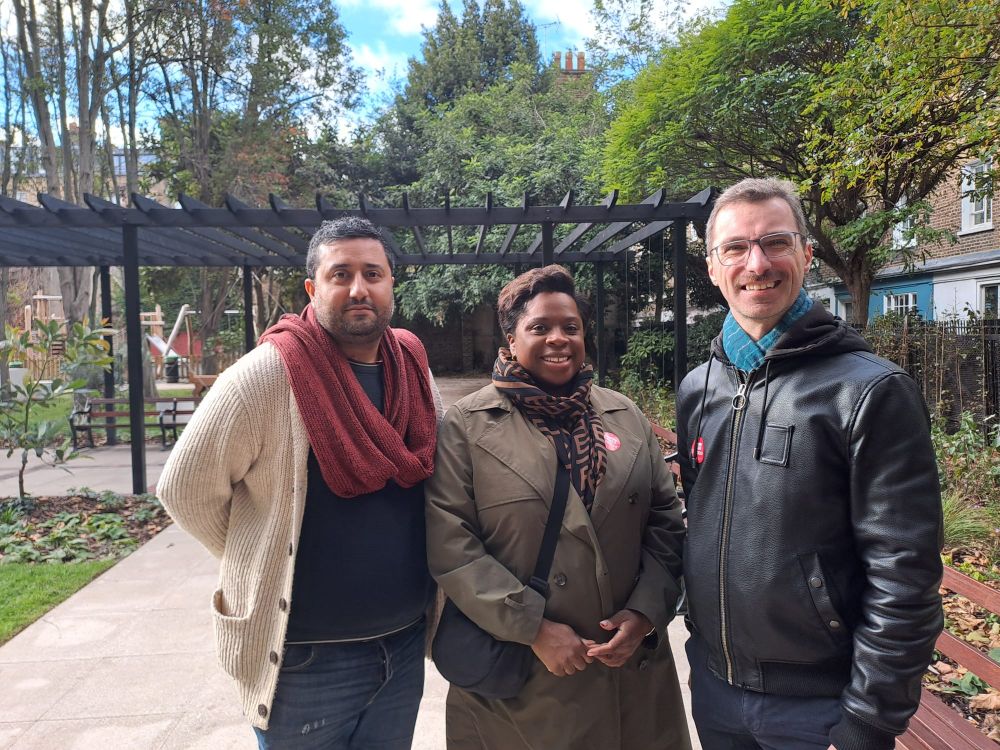 Photo of Rishi Madlani, Sabrina Francis and Adam Harrison standing in a park visible around and behind them including a pergola and trees