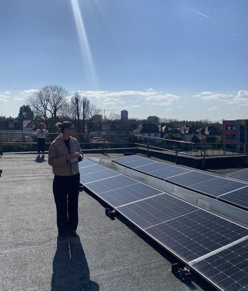 Photo of a woman looking at solar panels installed on a roof