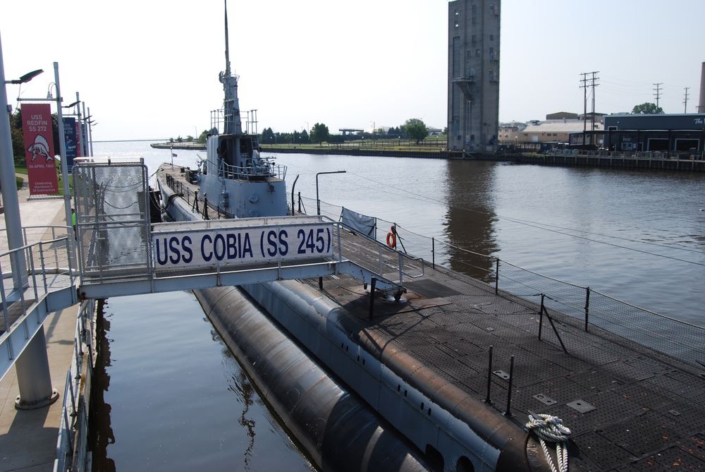 The USS Cobia, a WWII submarine that sits in the water outside the museum, looking at it from the aft and also showing the gang plank that provides access.