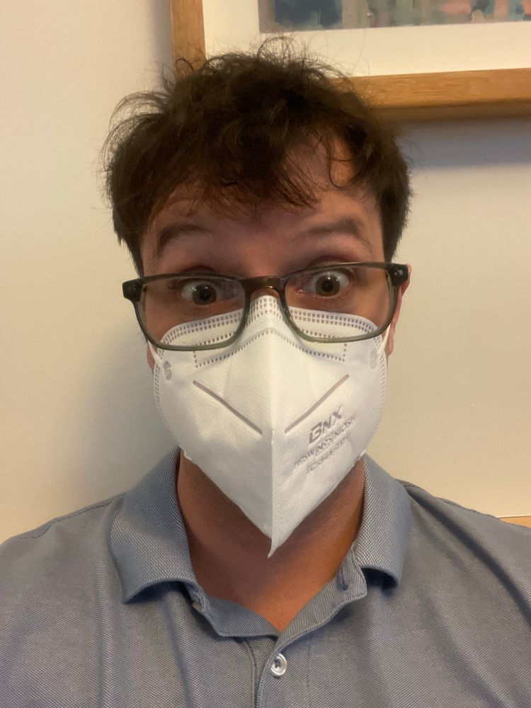 White guy in glasses wearing white BNX N95 flatfold mask.