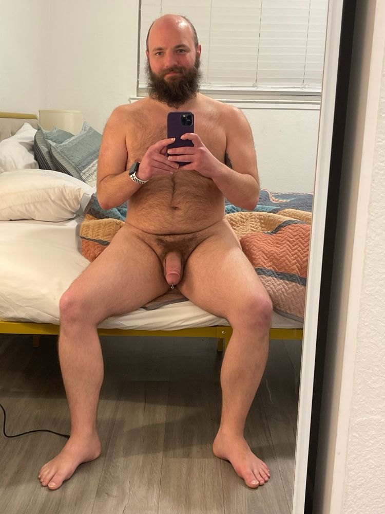 Hairy pup with a semi hard pa cock sitting on a bed