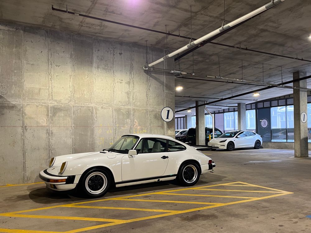a 1987 porsche 911 parked in a garage