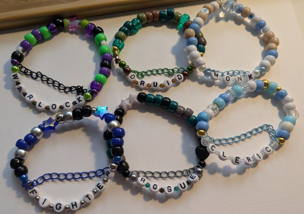 six kandi bracelets. they say warlock, druid, monk, fighter, rogue, and cleric