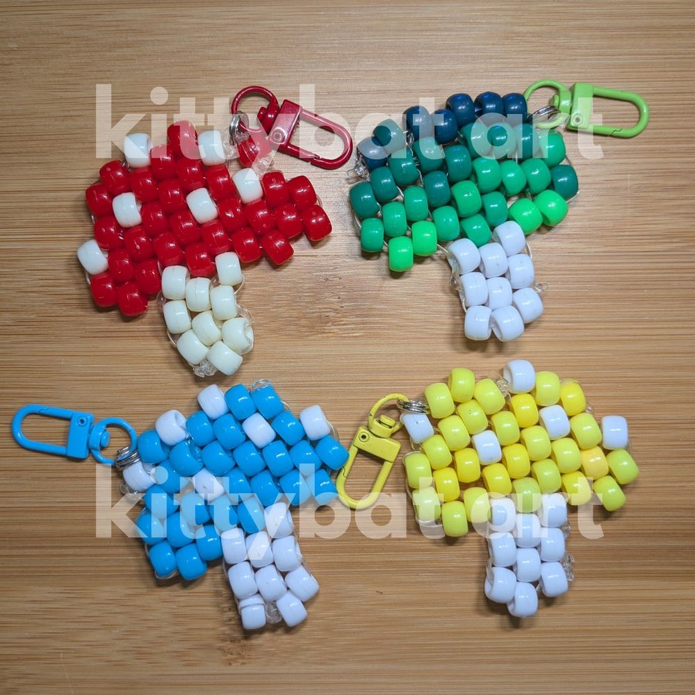 4 mushroom keychains made of pony beads. there is a red, green, blue, and yellow one.