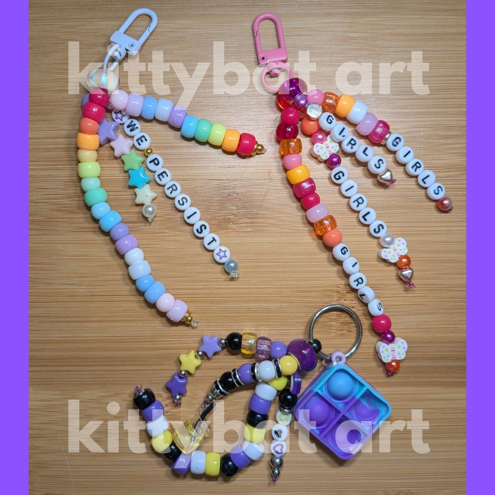 three pony bead keychains with rainbow, non-binary, and lesbian flag colors