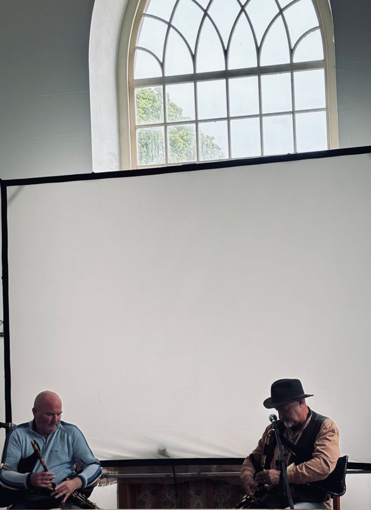 The two pipers playing in front of a screen in St Thomas’s Church, Rathlin island.