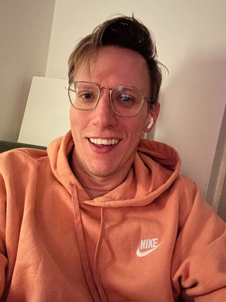 photo of brian wearing a pink Nike hoodie and wire-framed glasses