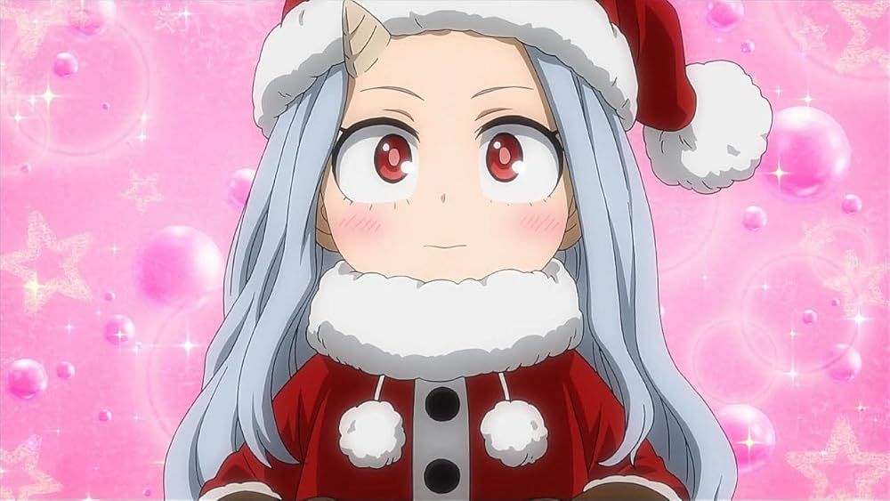Eri dressed in a cute Santa outfit while standing in front of a pink bubble background.