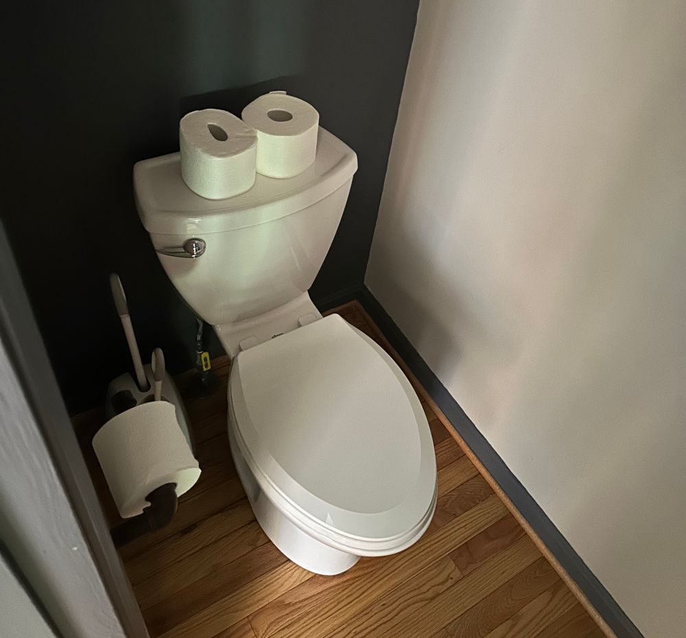 A toilet with 2 things of toilet paper on the top of it next to each other and i thought they were eyes 