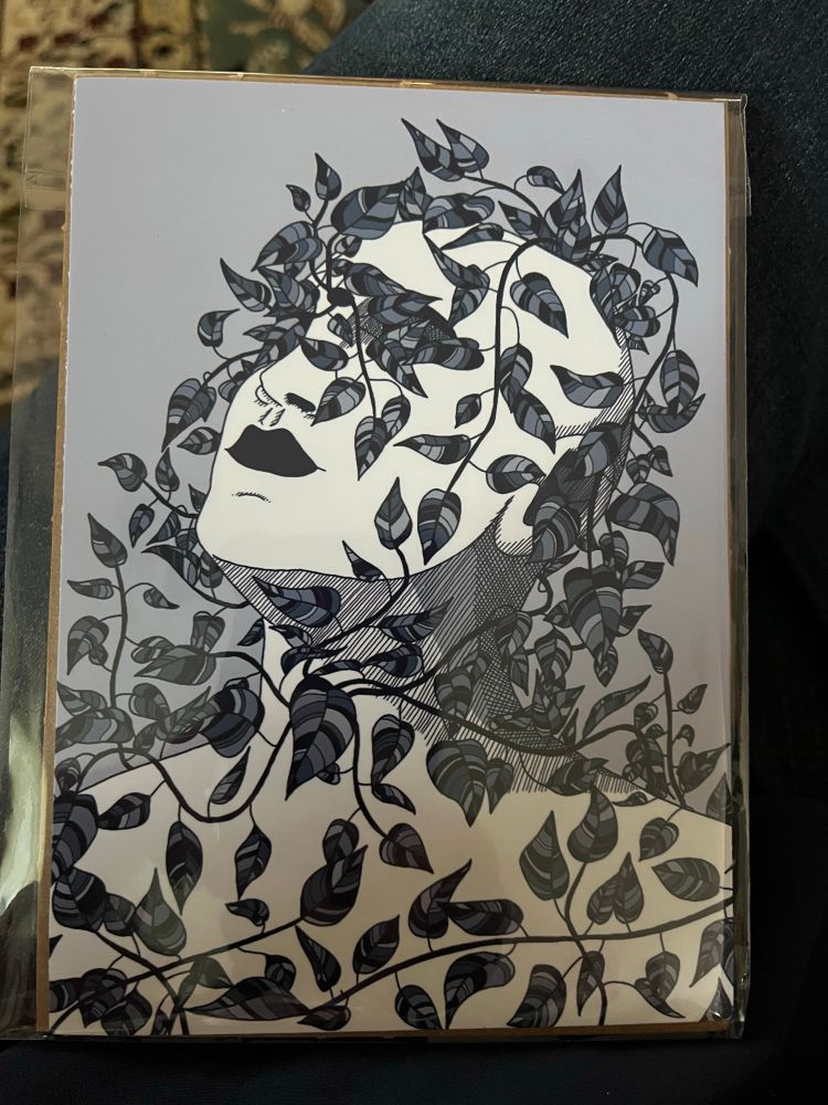 Little print of a person’s head and neck encircled by leaves