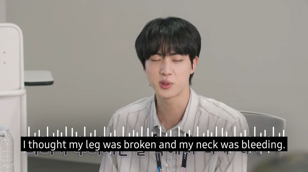 Screenshot of Jin at an office workplace describing his day. He’s saying: I thought my leg was broken and my neck was bleeding.