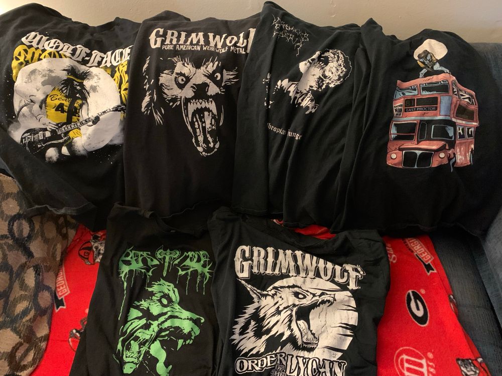 a line of 6 t-shirts with werewolves on them, mostly band tees: wolf-face, grimwolf, werewolves in siberia, a graphic tee of teen wolf on top of a london bus, beast mode, and another grimwolf shirt