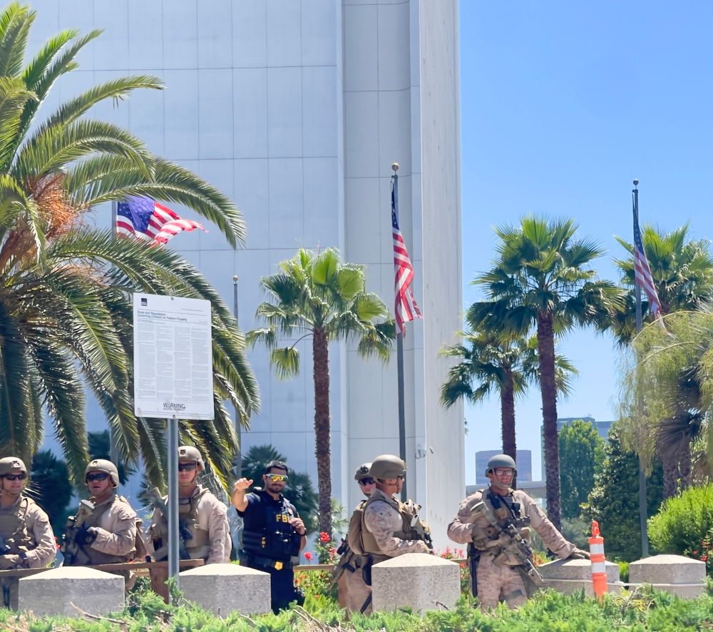 Troops, plus a waving FBI agent, outside the federal building in Westwood in June. 