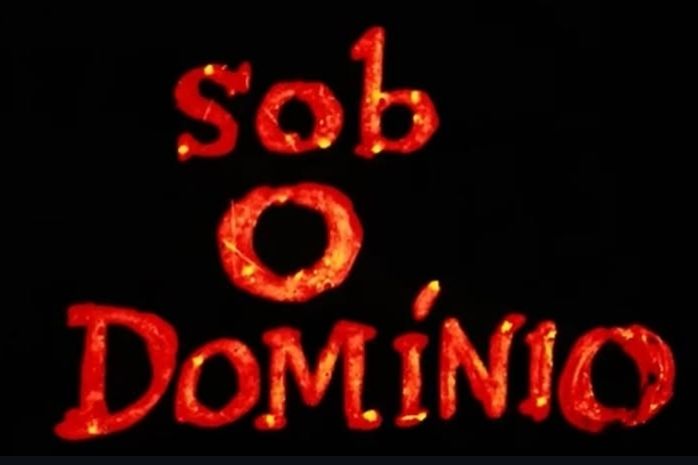 titulo do filme "Sob o Domínio" em vermelho alaranjado num fundo preto