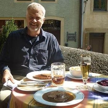 Dr. Len Friesen in front of a restaurant table
