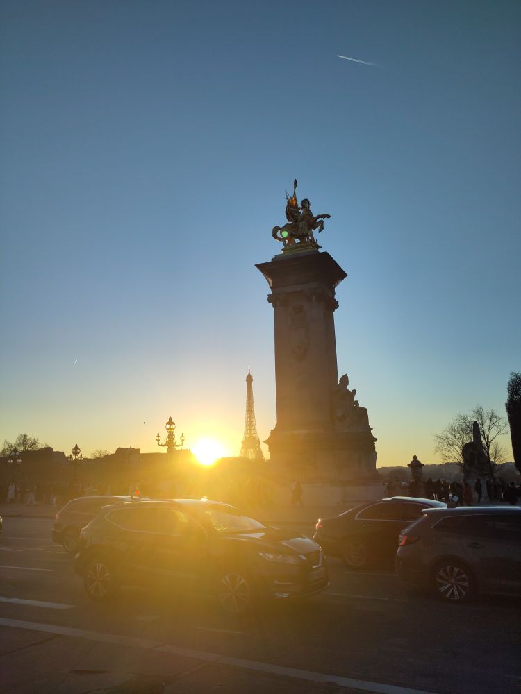 Le soleil se couchant sur le pont des Invalides à Paris. On voit la tour Eiffel dans le contre jour.