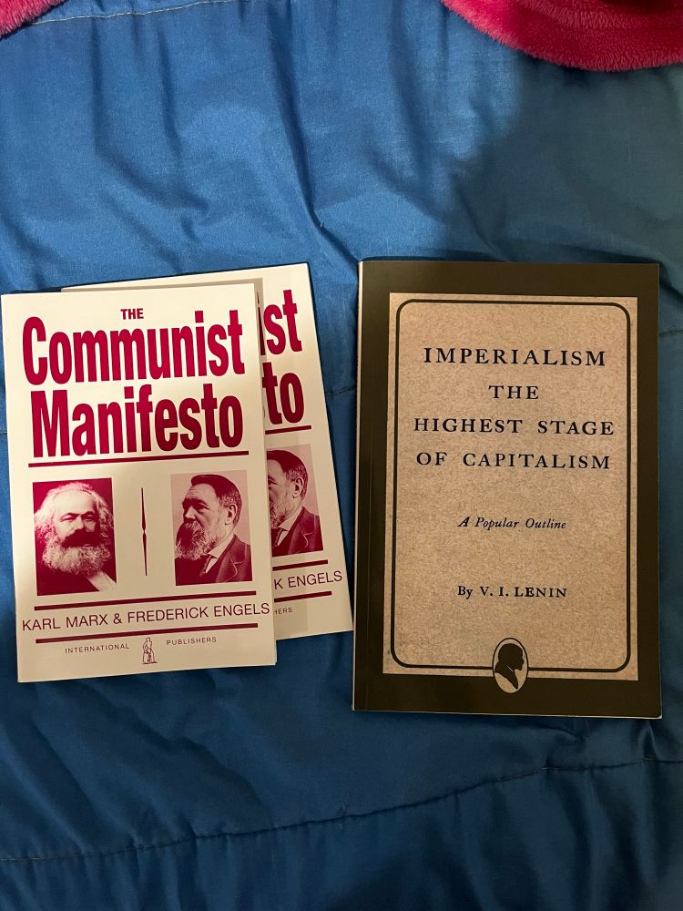 An image of three books total. To the left are two copies of The Communist Manifesto by Karl Marx and Frederick Engels, and to the right is Imperialism: The Highest Stage of Capitalism by Vladimir Lenin.