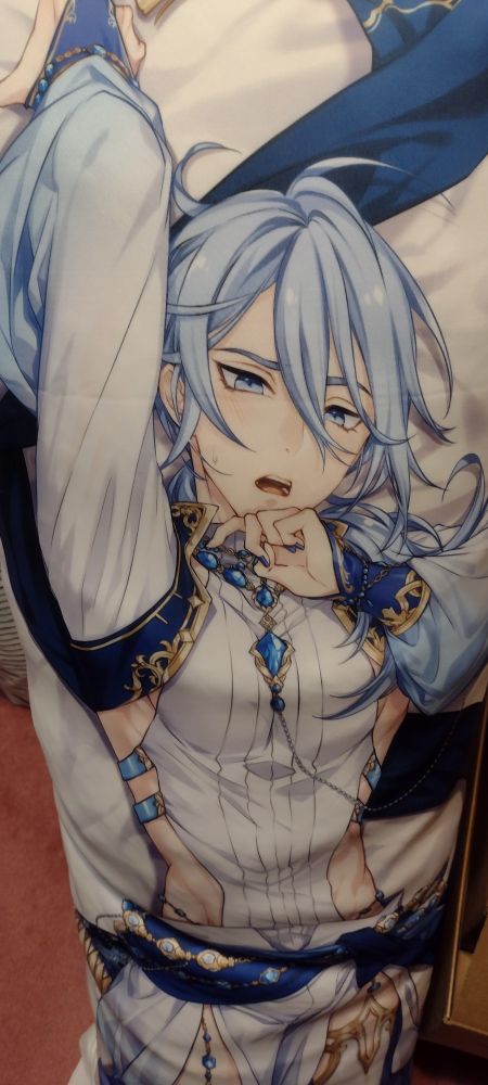 A blue haired man looking bashful on a body pillowcase.